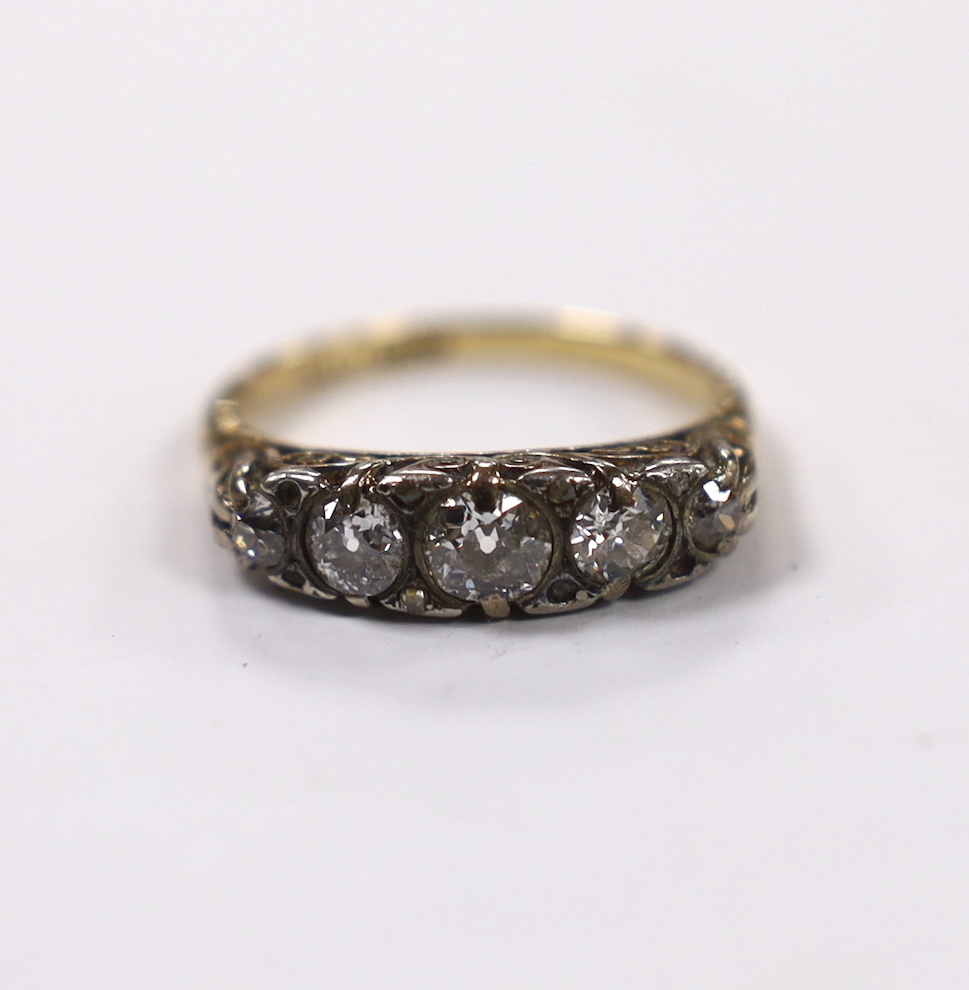 An early 20th century 18ct, plat and graduated five stone diamond set half hoop ring, with diamond chip spacers (four missing), size O, gross weight 4.3 grams.